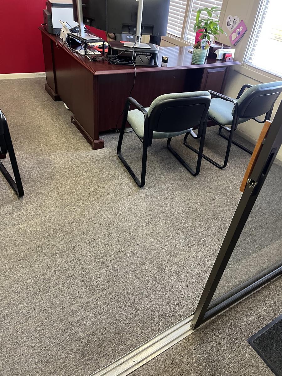 Office desk and guest chairs on freshly vacuumed carpet