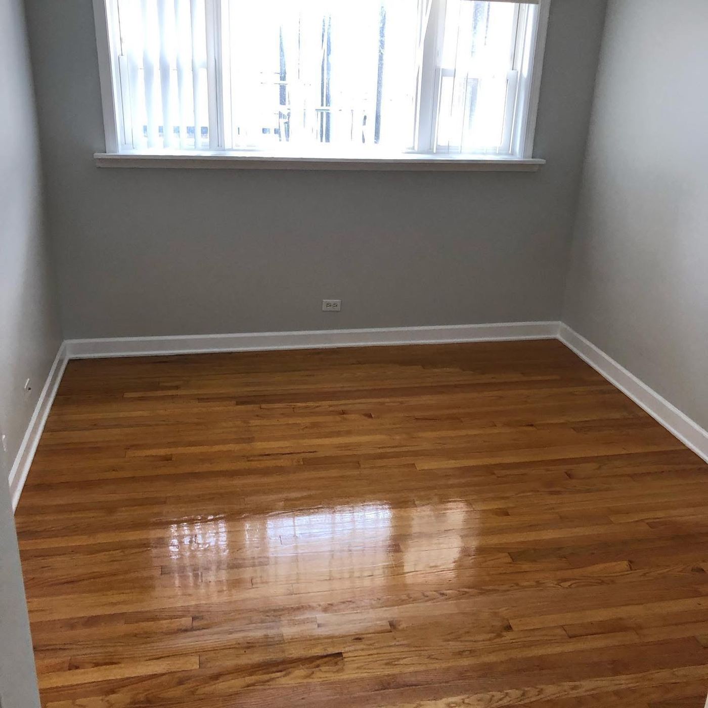 Empty room with polished hardwood floor ready for move-in after cleaning
