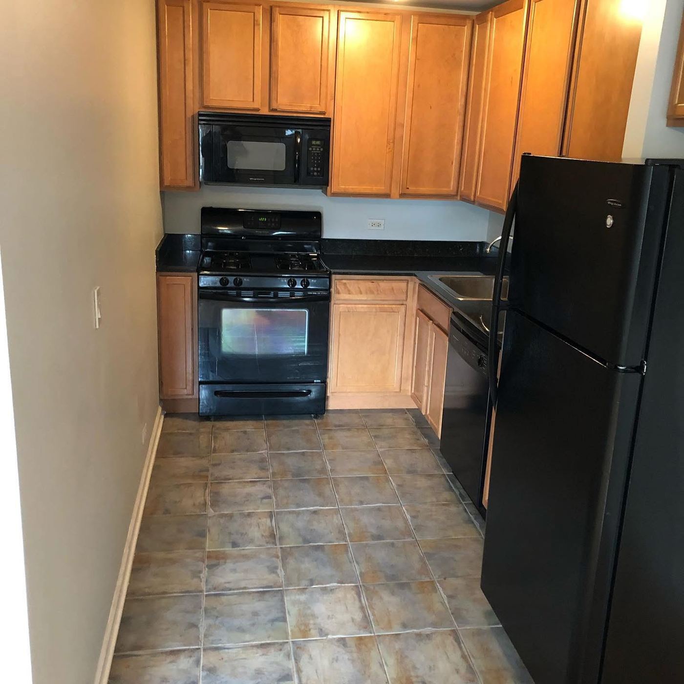 Rental unit kitchen with clean appliances and tile floor after cleaning