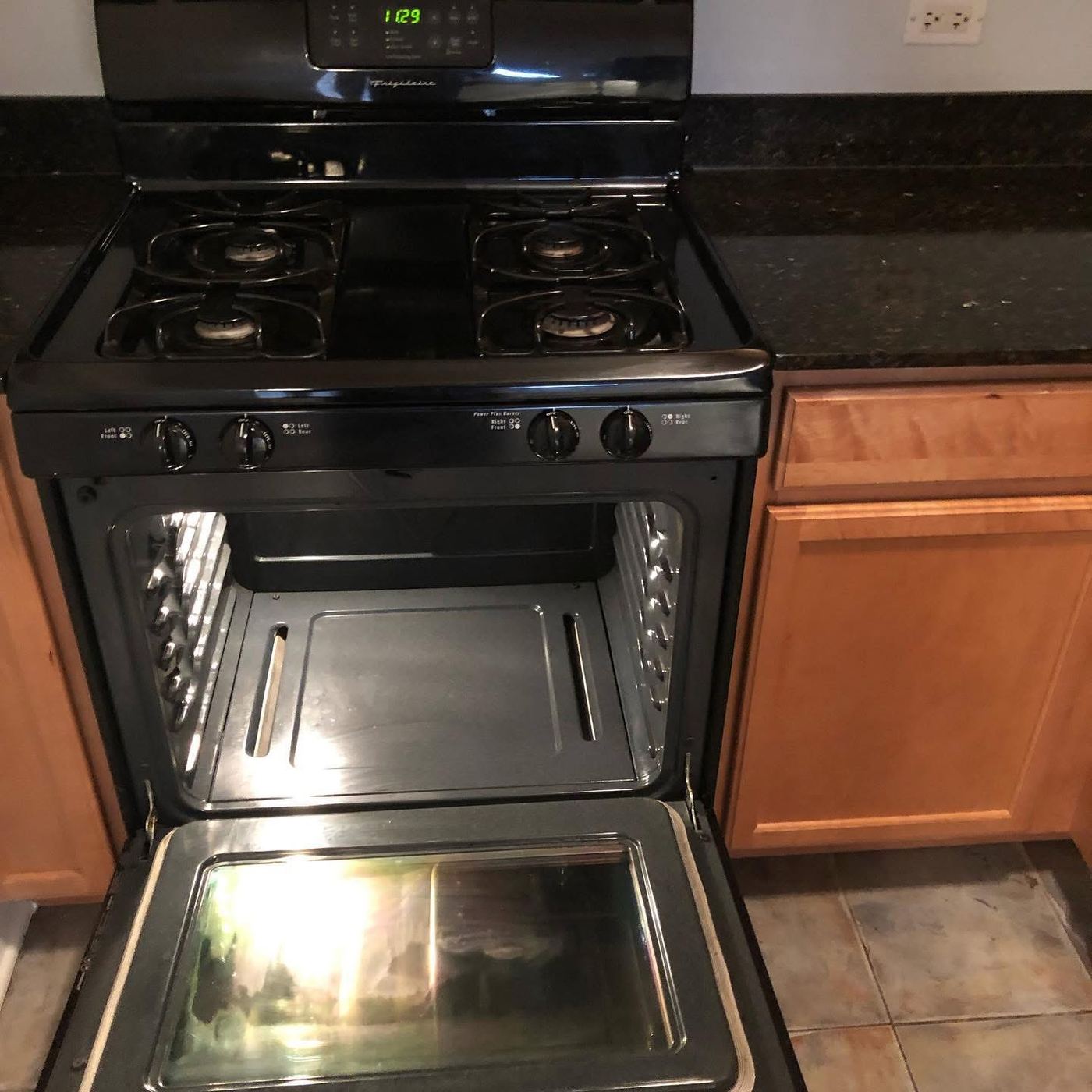 Gas range with open oven cleaned during a rental unit turnover