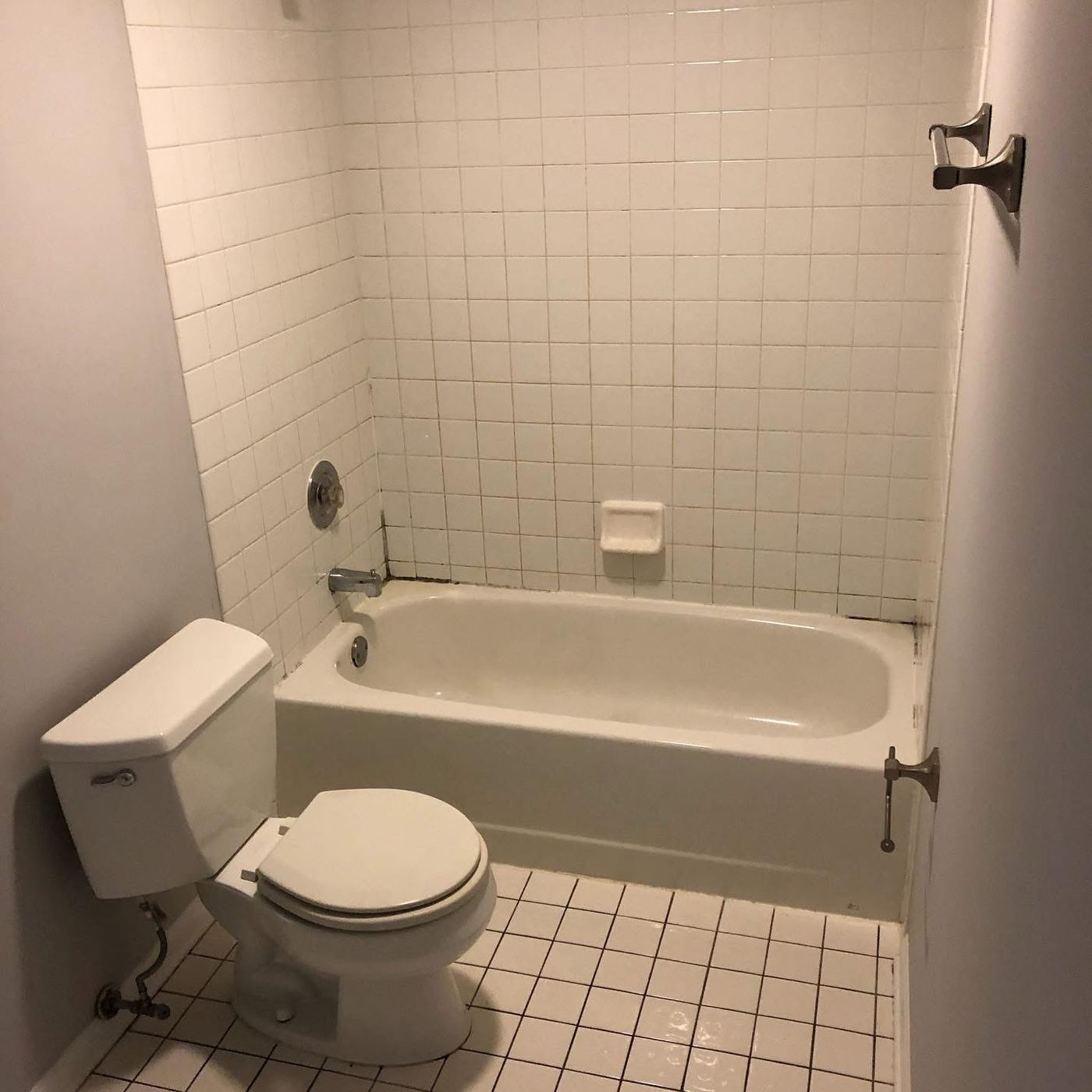 Clean bathroom with tub and white tile ready for the next tenant