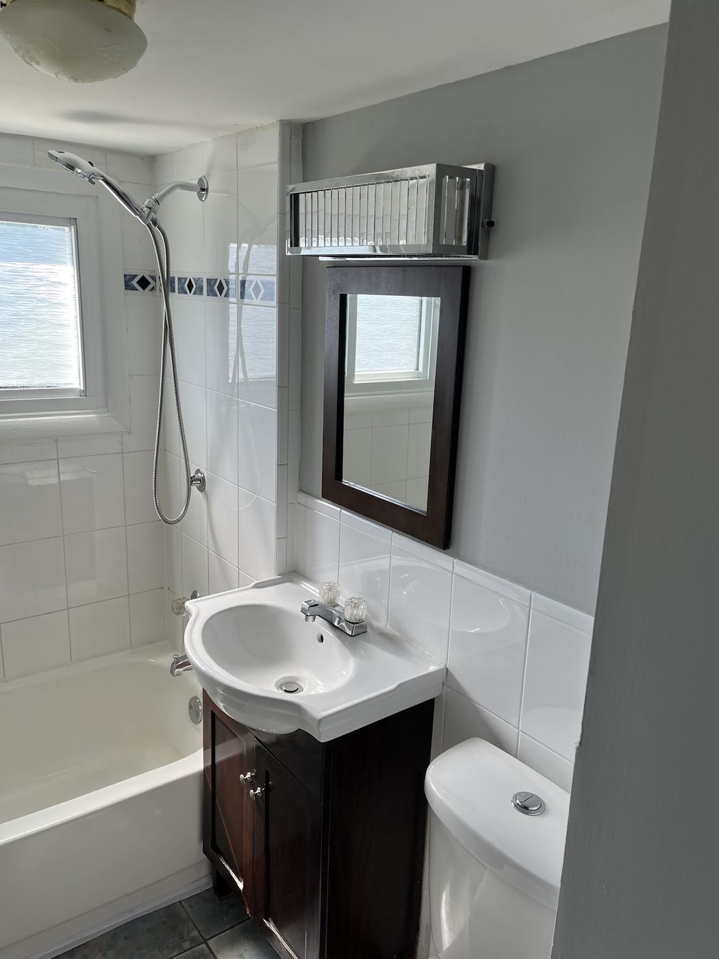 Bright bathroom with clean vanity, mirror and tub ready for showings