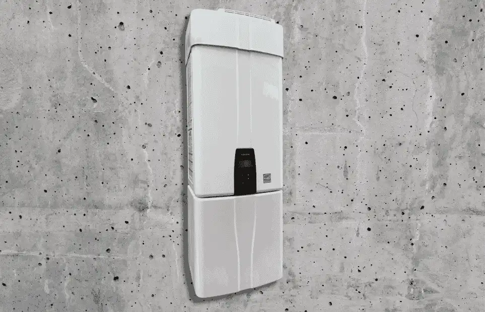 A white water heater installed on a cement wall. 