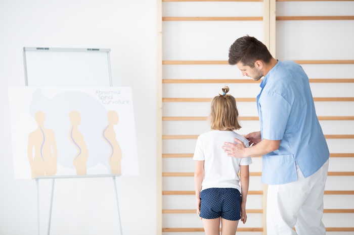 Chiropractor assessing young child's spine at pediatric chiropractic clinic in North Chesterfield VA