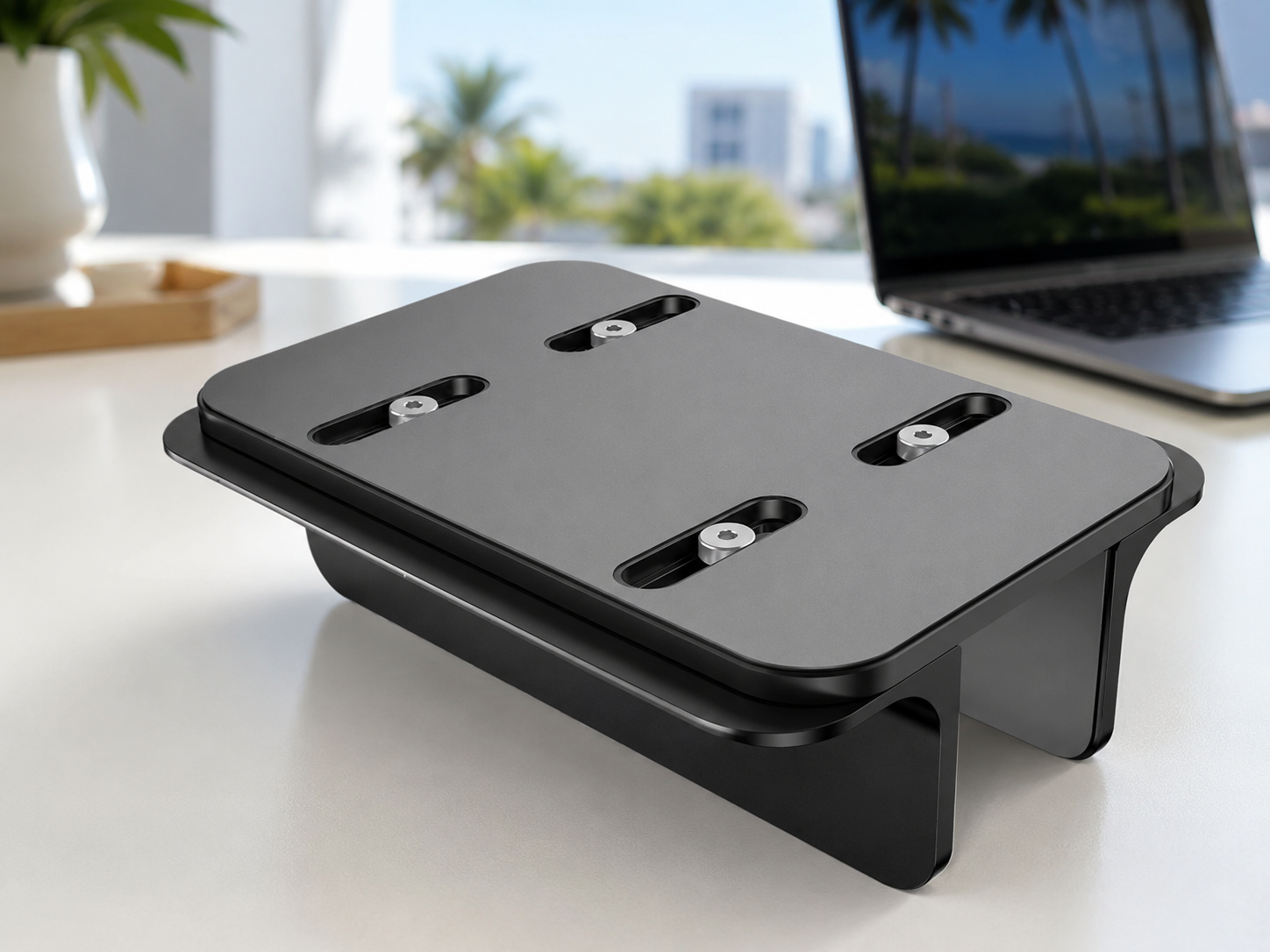 Close-up detail of the OMOTON stand showing the adjustable screws on the bottom and the non-slip silicone mat