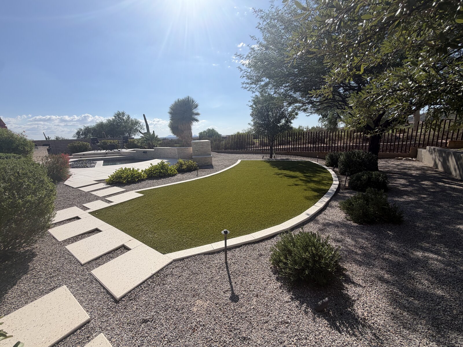 Backyard artificial turf oval with paver stepping stones