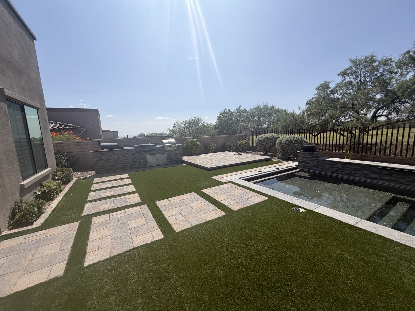 Backyard with artificial turf, pavers, pool and outdoor kitchen