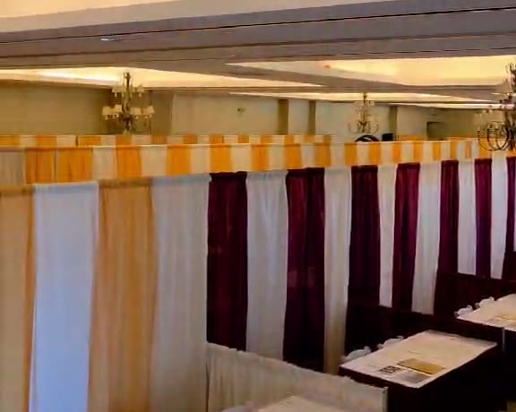 Ballroom set with rows of pipe and drape booths