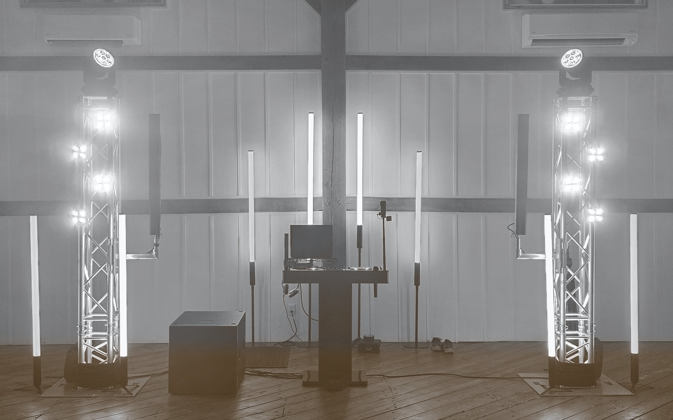 Wedding DJ booth with white uplighting, light tubes and two moving head lights on vertical truss