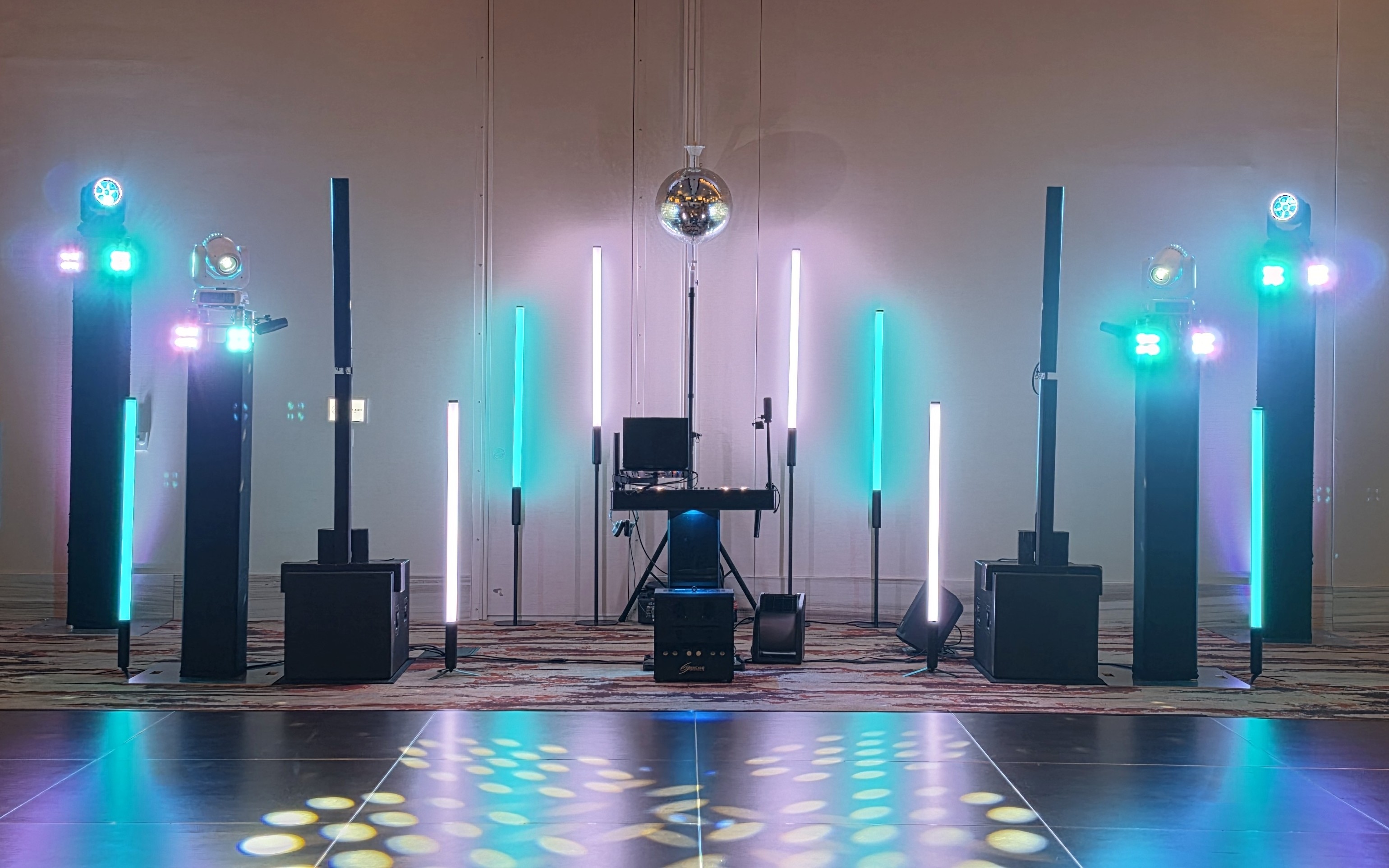 Full DJ setup with four moving head lights, light tubes, a disco ball and lighting effects across the dance floor