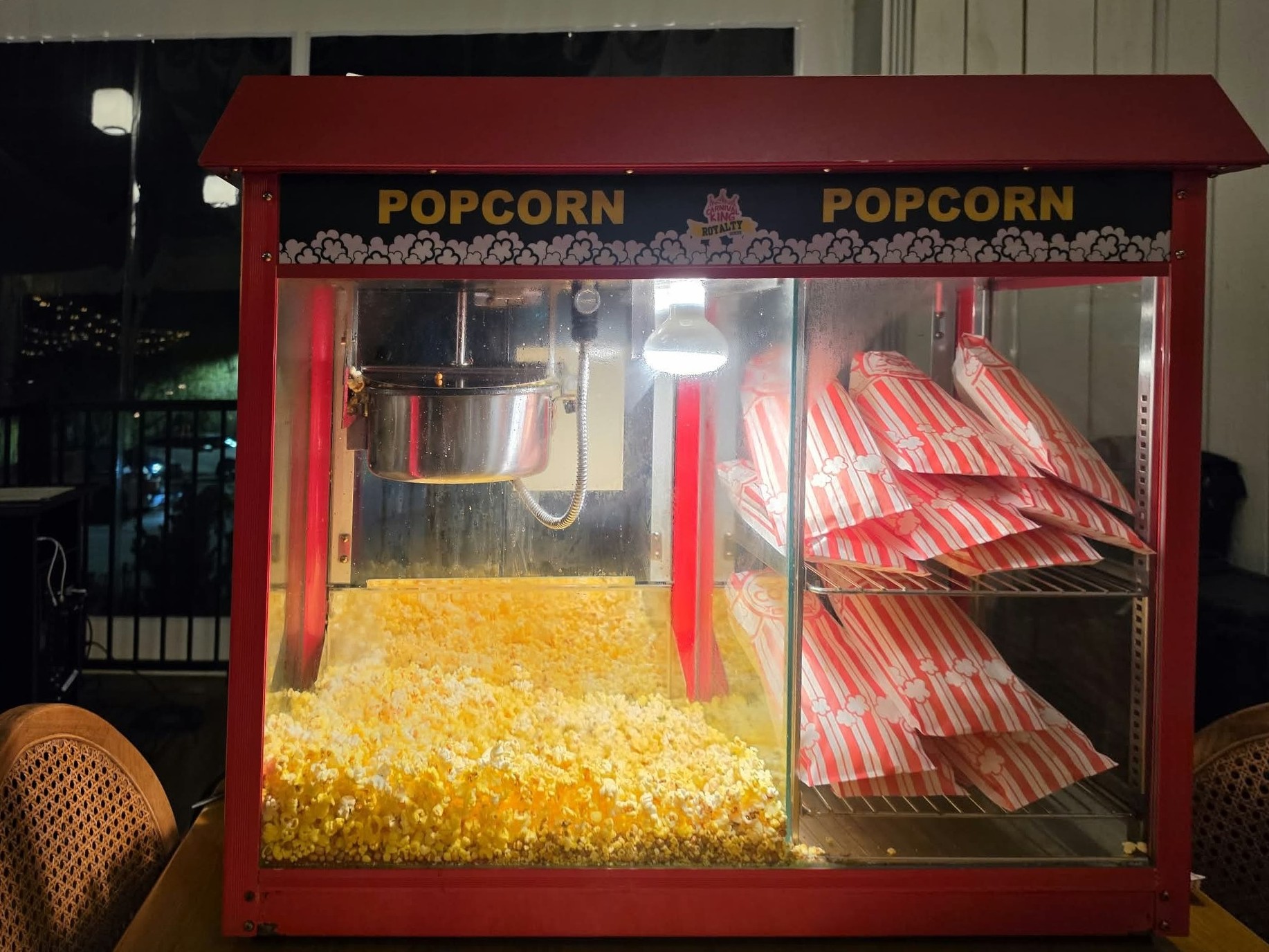 Red concession-style popcorn machine full of fresh popcorn