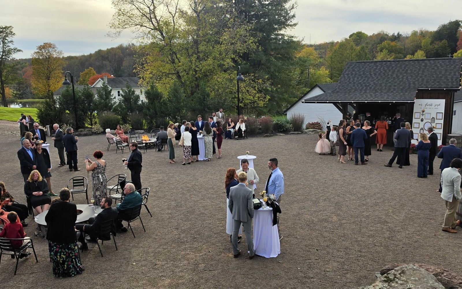 Wedding cocktail hour with a fire pit, cocktail tables and a bar