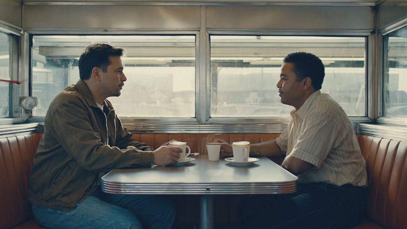 Two business owners talking over coffee at a diner booth