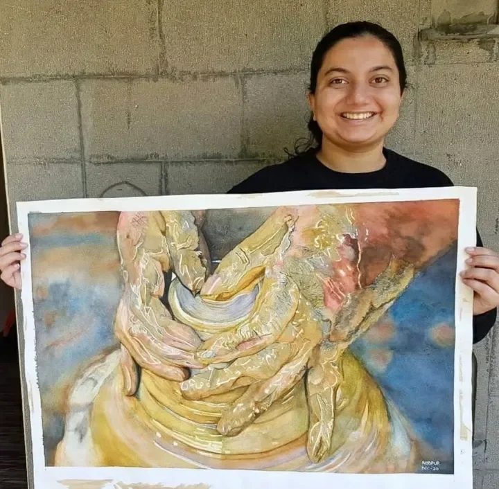 Dr. Noopur Panchanadikar with a finished realistic watercolor painting