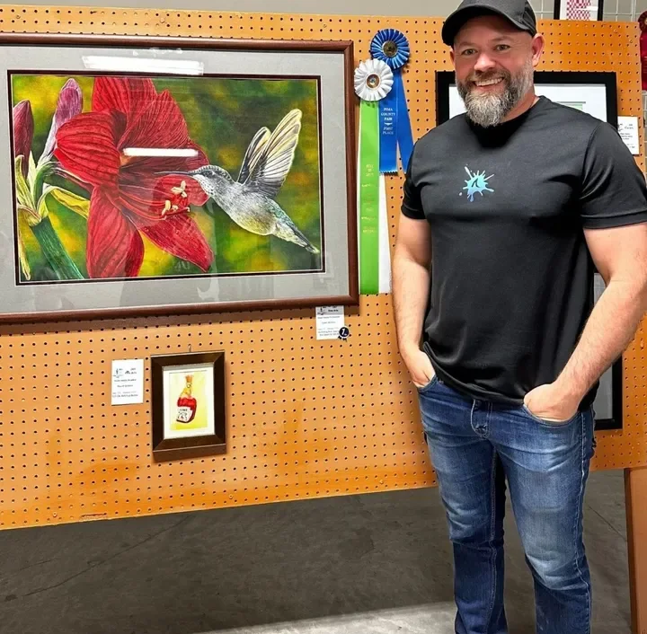 Caleb Grimes with a finished realistic watercolor painting