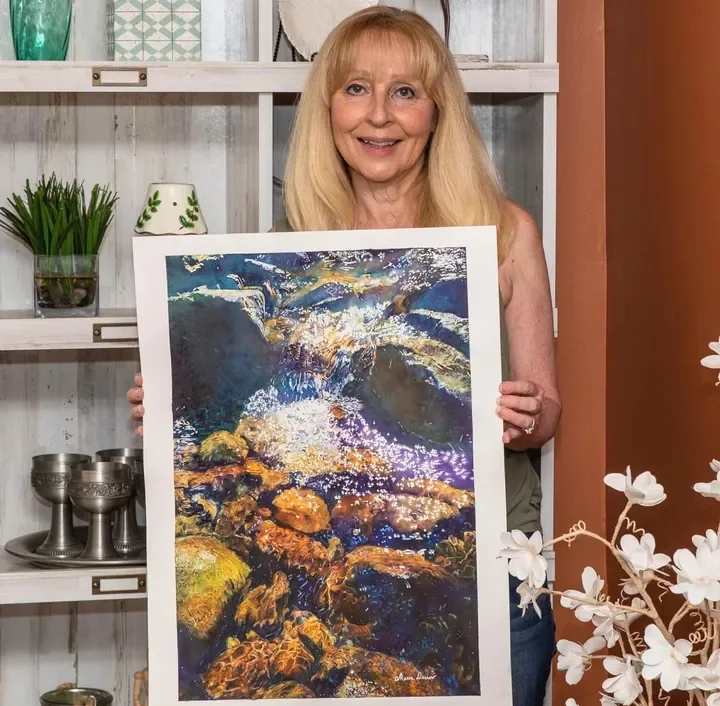 Sharon Darrow with a finished realistic watercolor painting