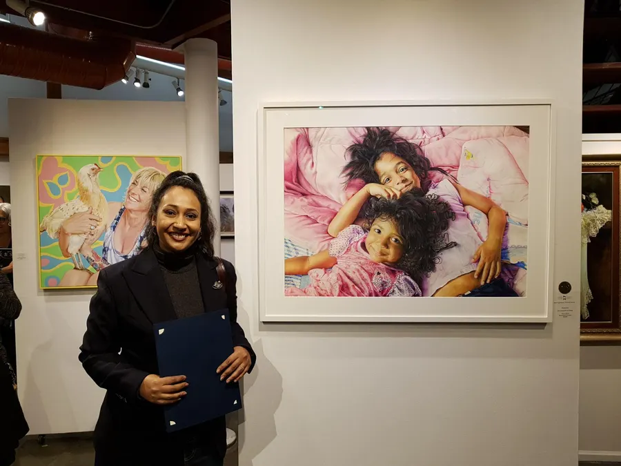 Meeta beside her painting at an exhibition