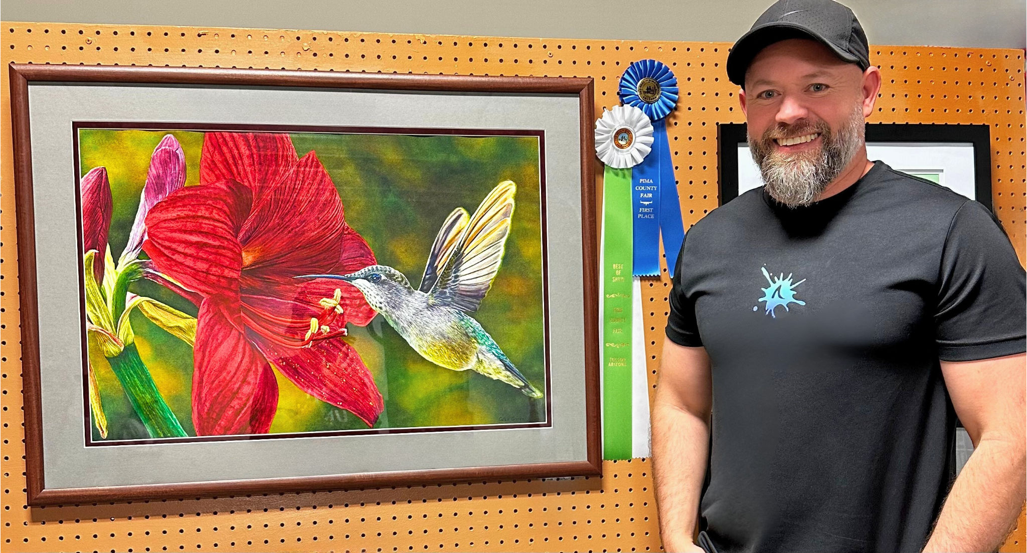 Caleb Grimes beside his watercolor painting Soul of the Desert, a hummingbird and red lily, with its Pima County Fair First Place and Best of Show ribbons