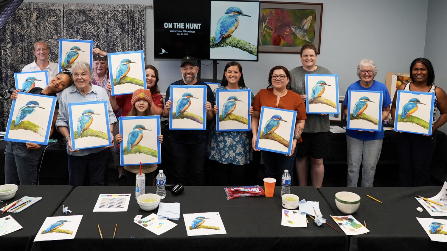 Caleb Grimes with his workshop students, each holding their finished kingfisher watercolor painting