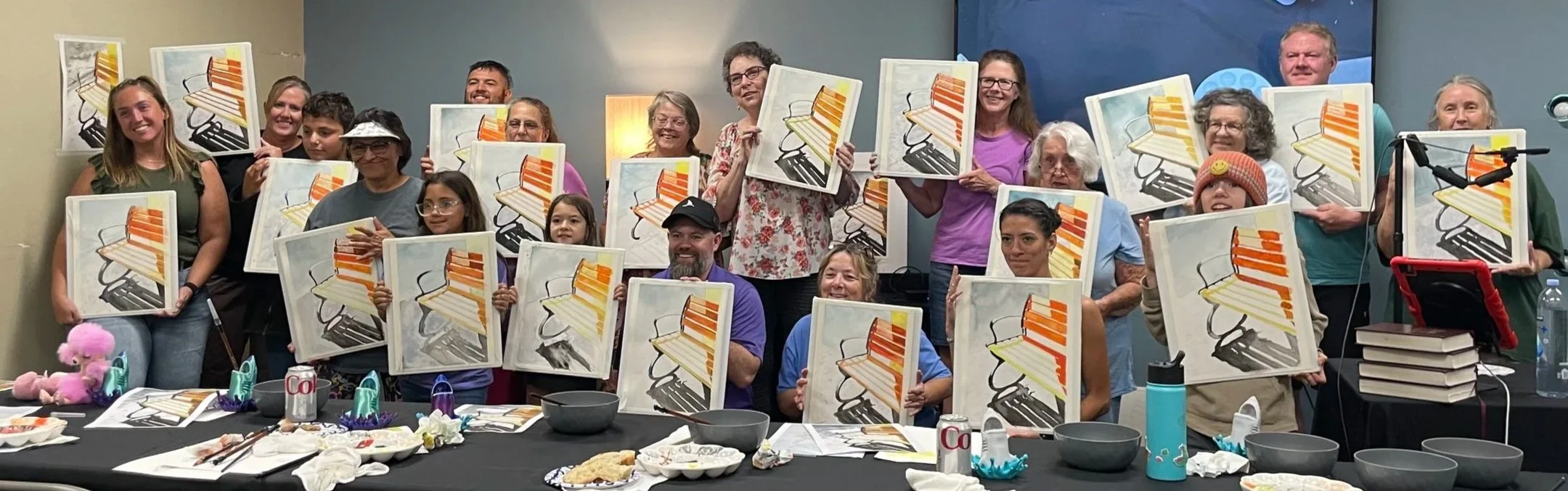 More than twenty of Caleb Grimes&rsquo;s workshop students holding their finished bench watercolor paintings