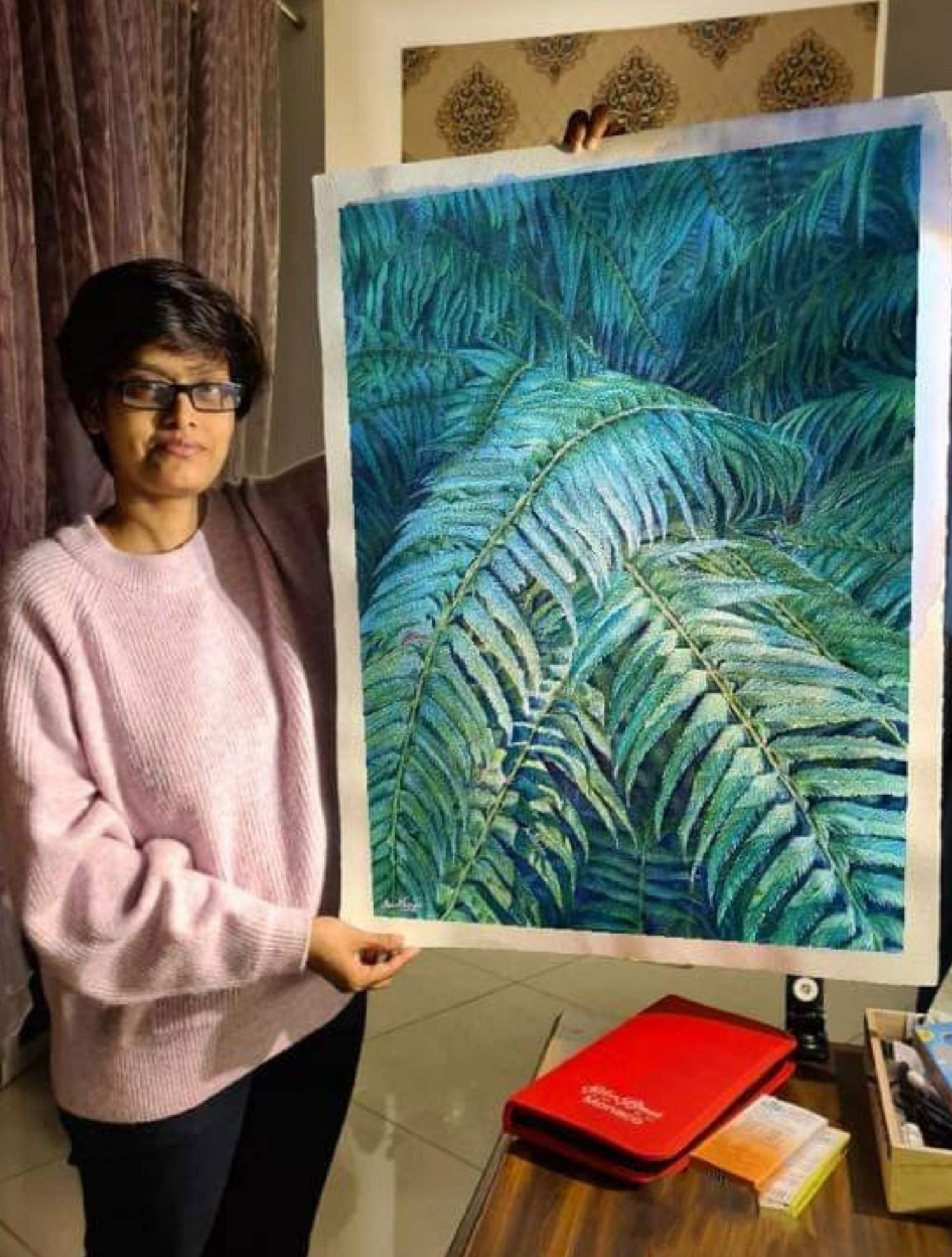 Madhubanti Mukherjee holding her fern painting