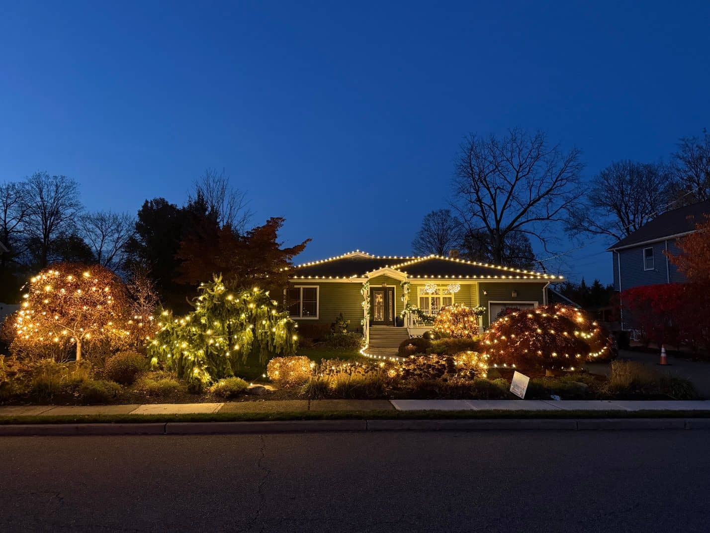 Professional Christmas lights installed on a New Jersey home at dusk