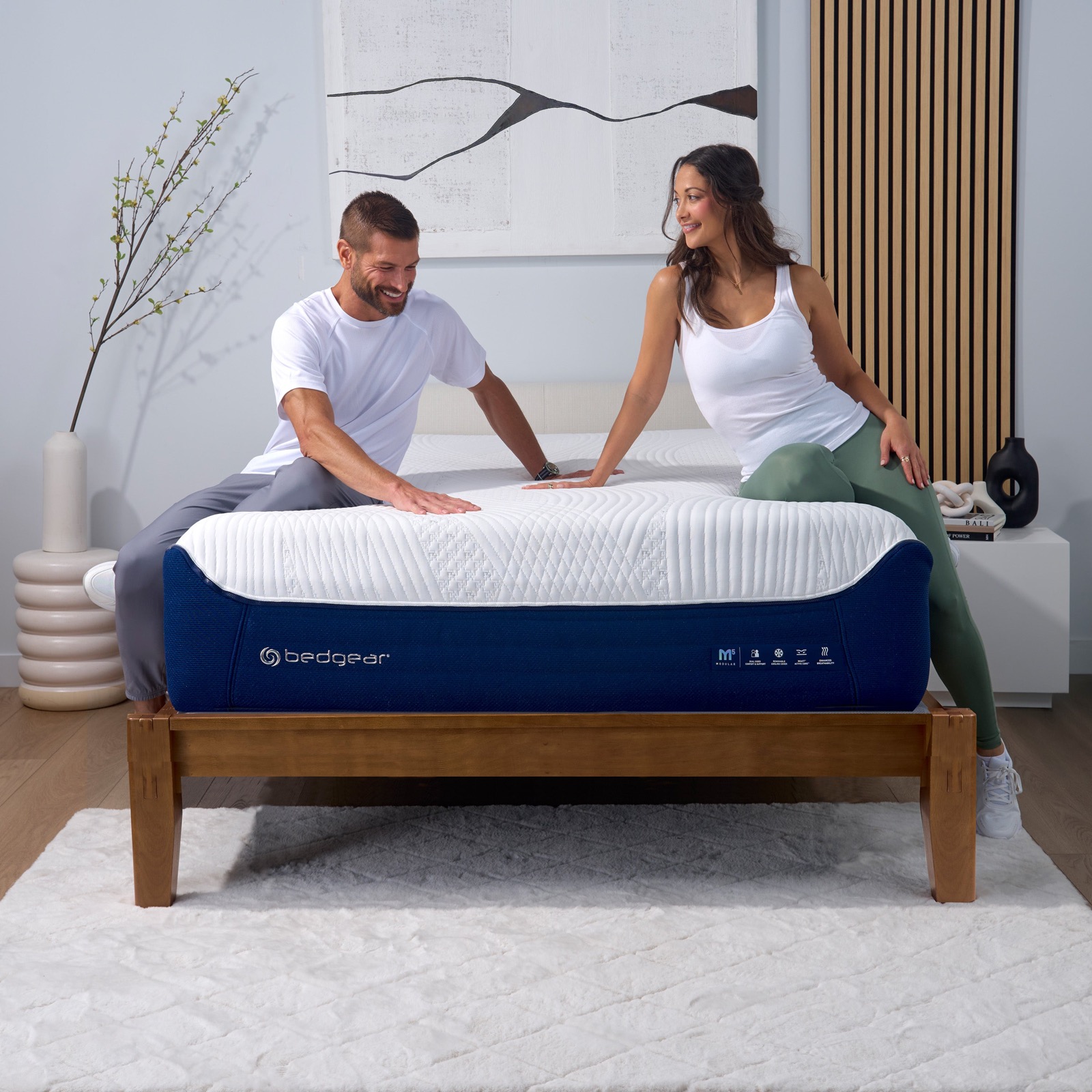 A bed frame dressed with a mattress in a bright Cork bedroom