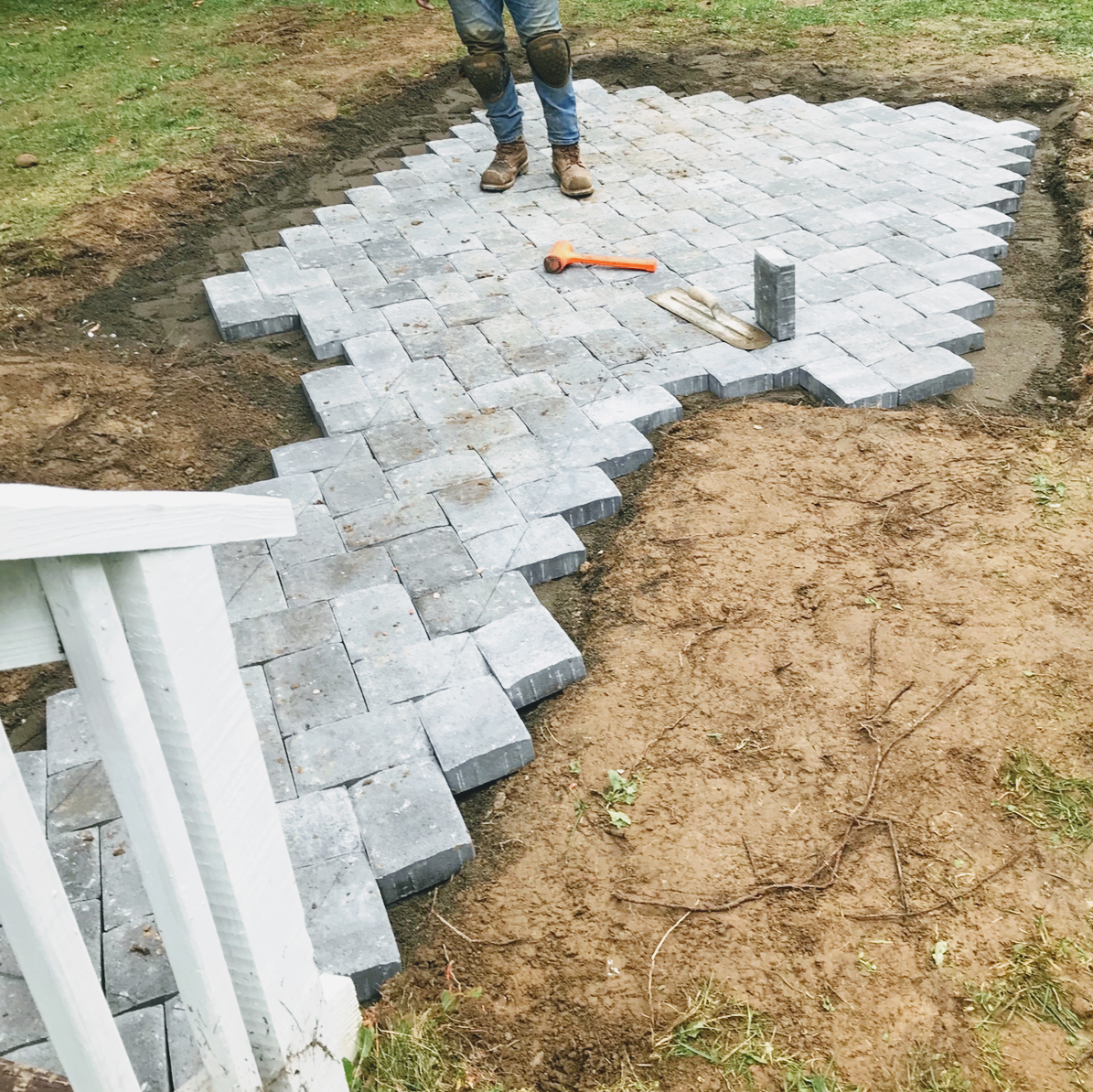 Paver installation in progress with tools on a dirt base, laid by Platinum Werx