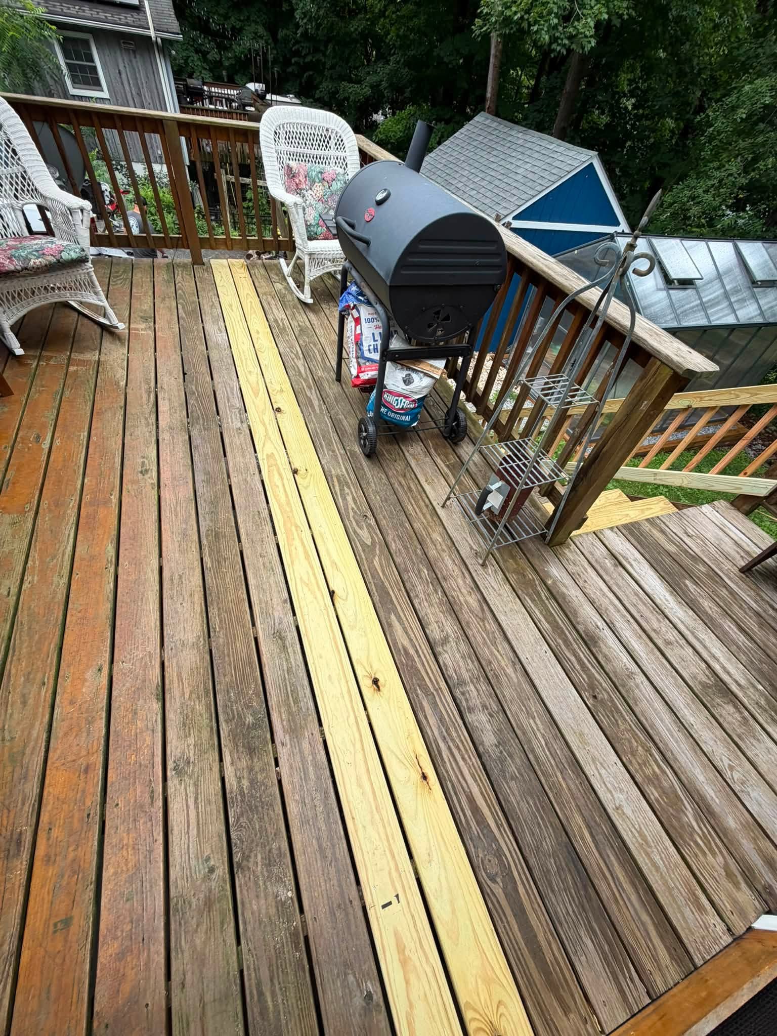 Finished wooden deck with chairs and a grill