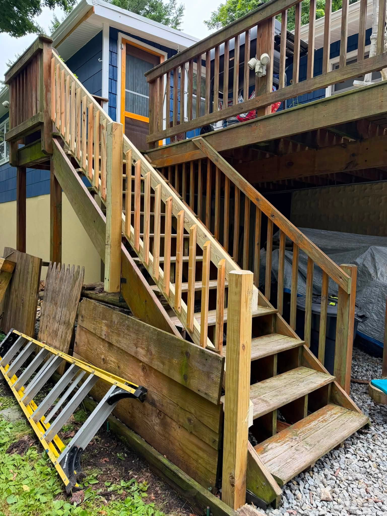 Wooden staircase with railing attached to the side of a house