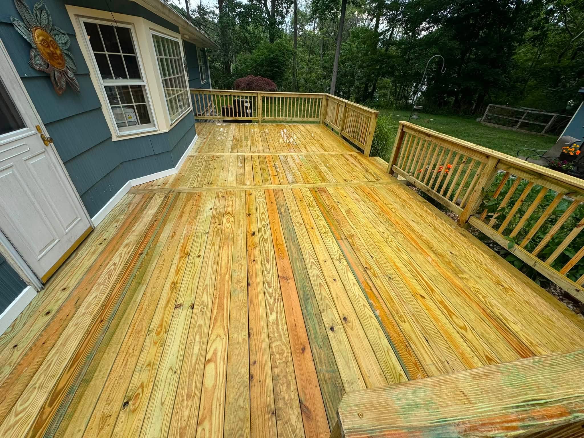 Wooden deck with railing along the side of a house