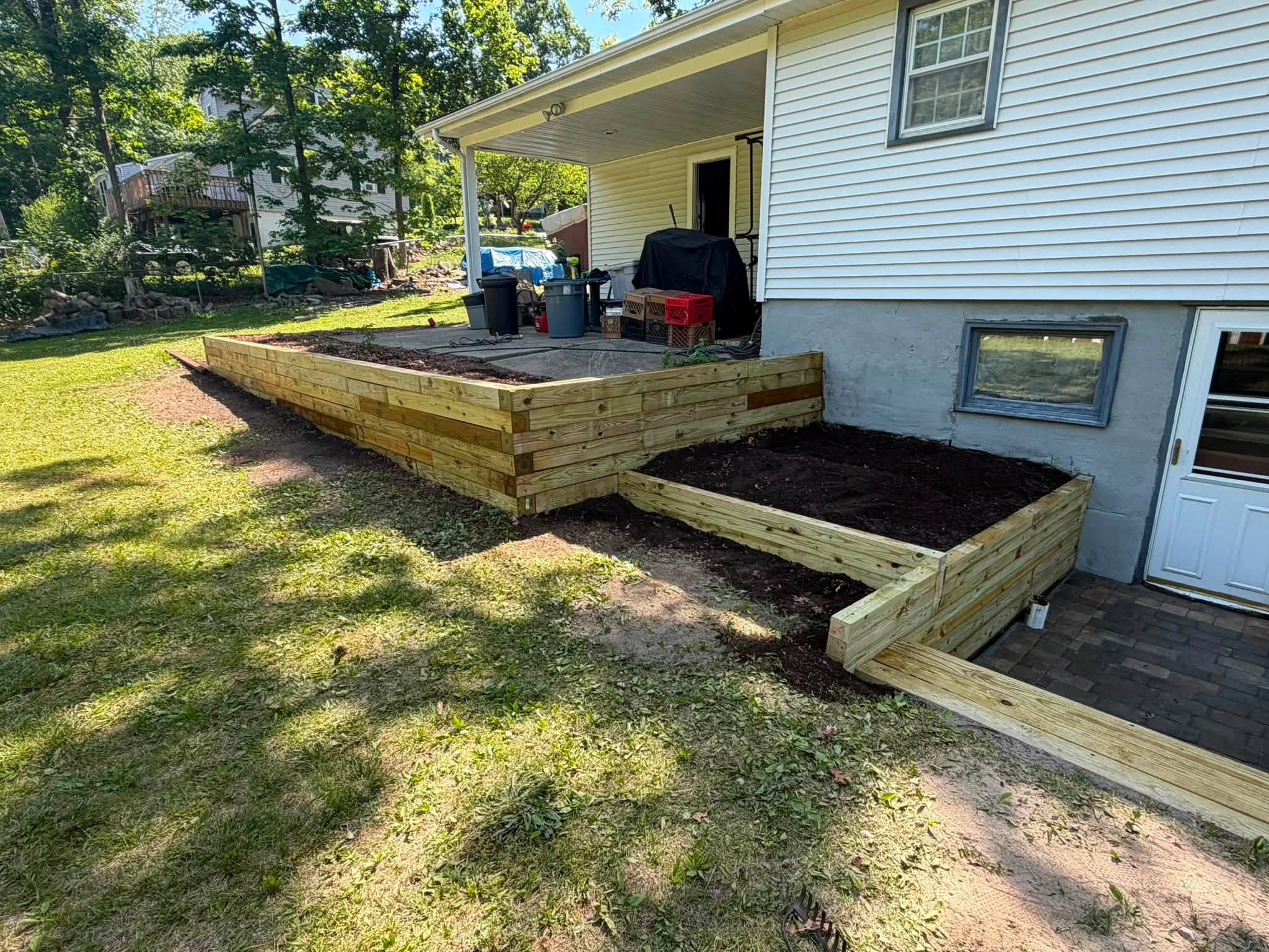 Wooden raised bed built against the side of a house