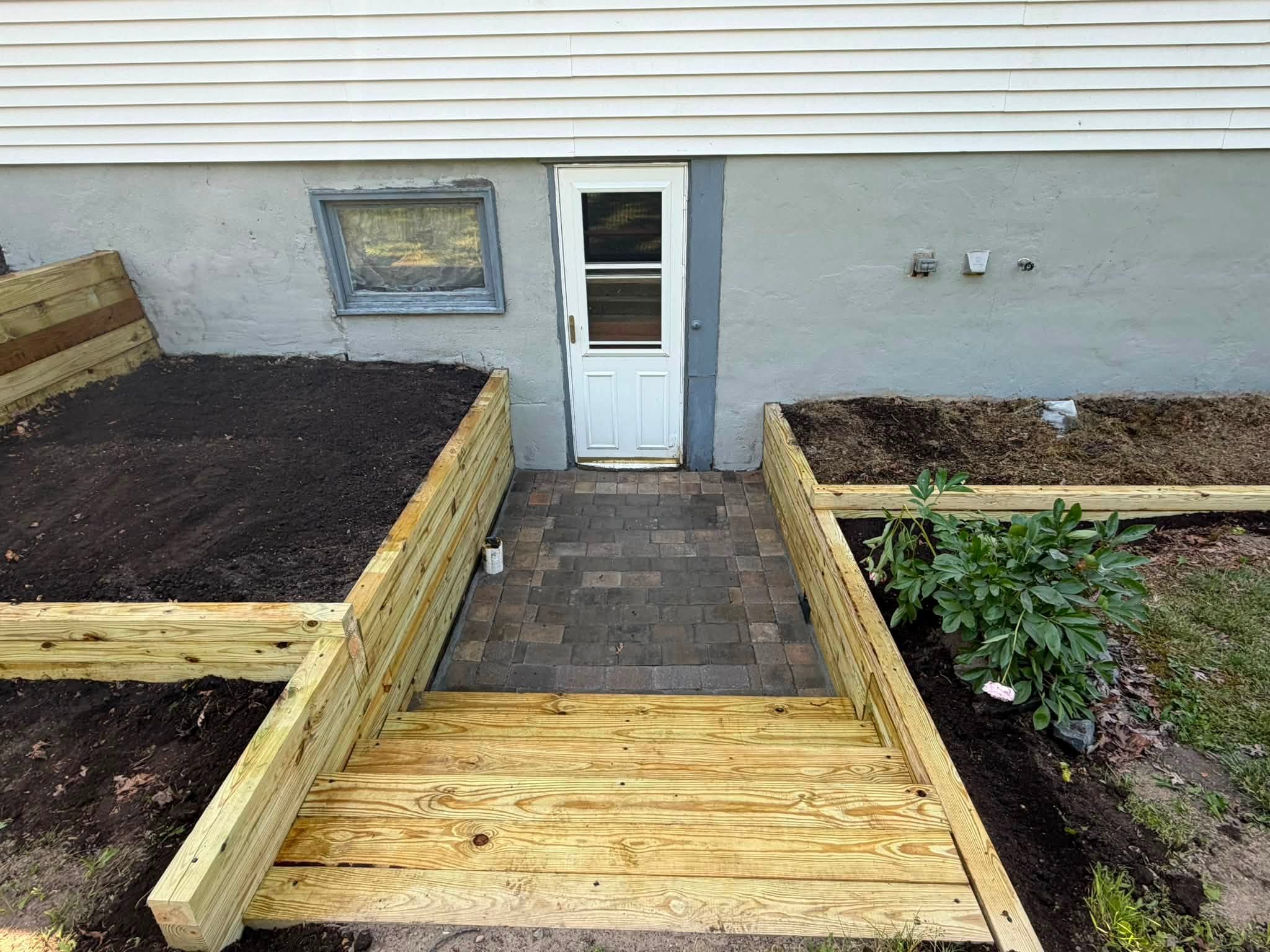 Wooden walkway leading to a white back door