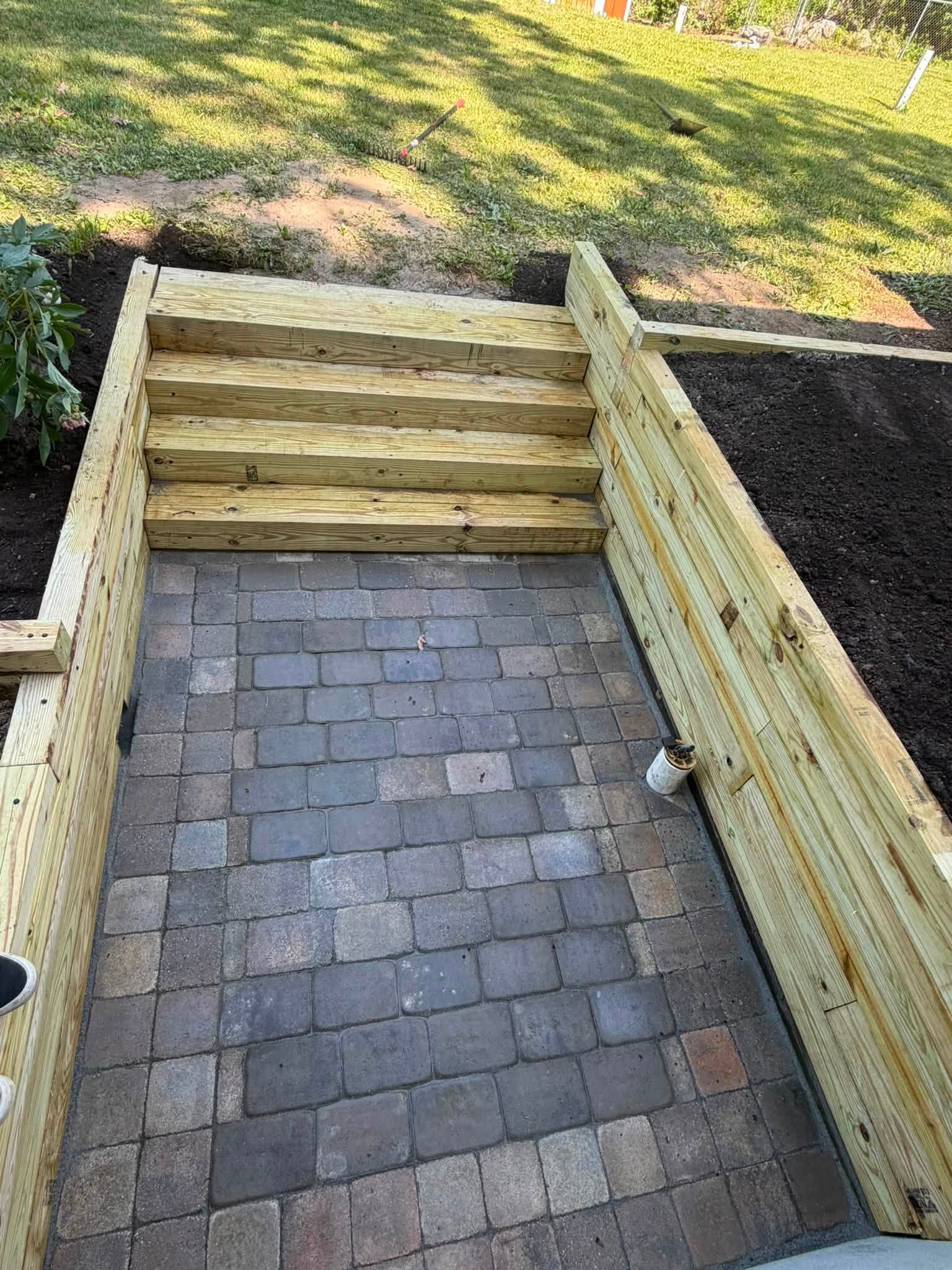 Wooden staircase with steps leading up to an elevated deck area