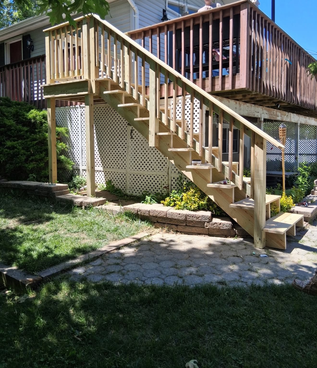 Wooden exterior staircase with railing leading to an upper deck built by Platinum Werx