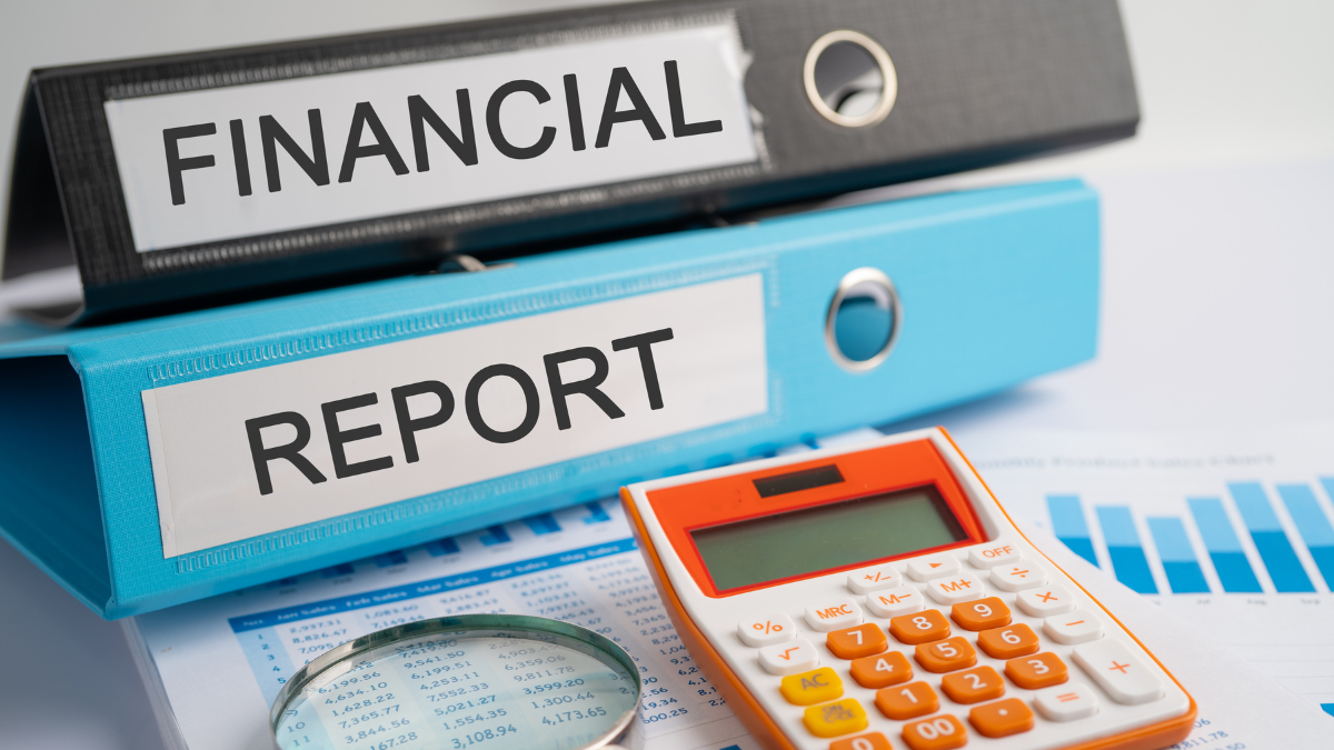 Financial reports and calculator used for a small business month-end bookkeeping review