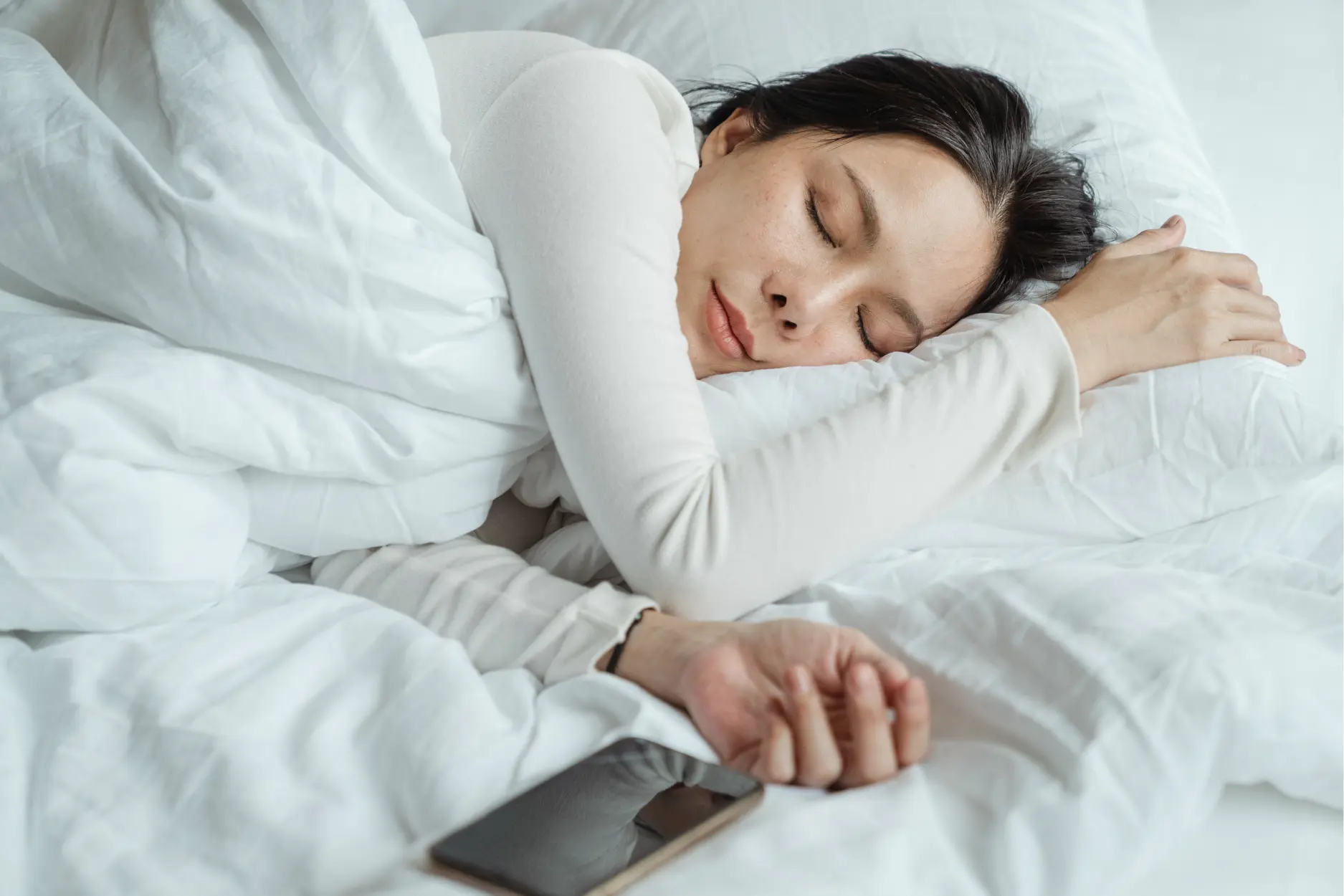 Gesunder Schlaf einer jungen Frau in ihrem gereinigten Bett