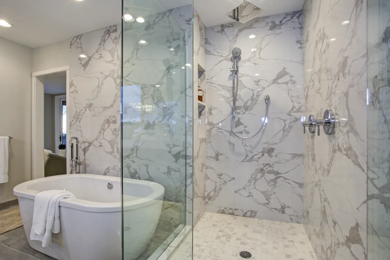 Marble bathroom remodel with a freestanding tub and glass shower