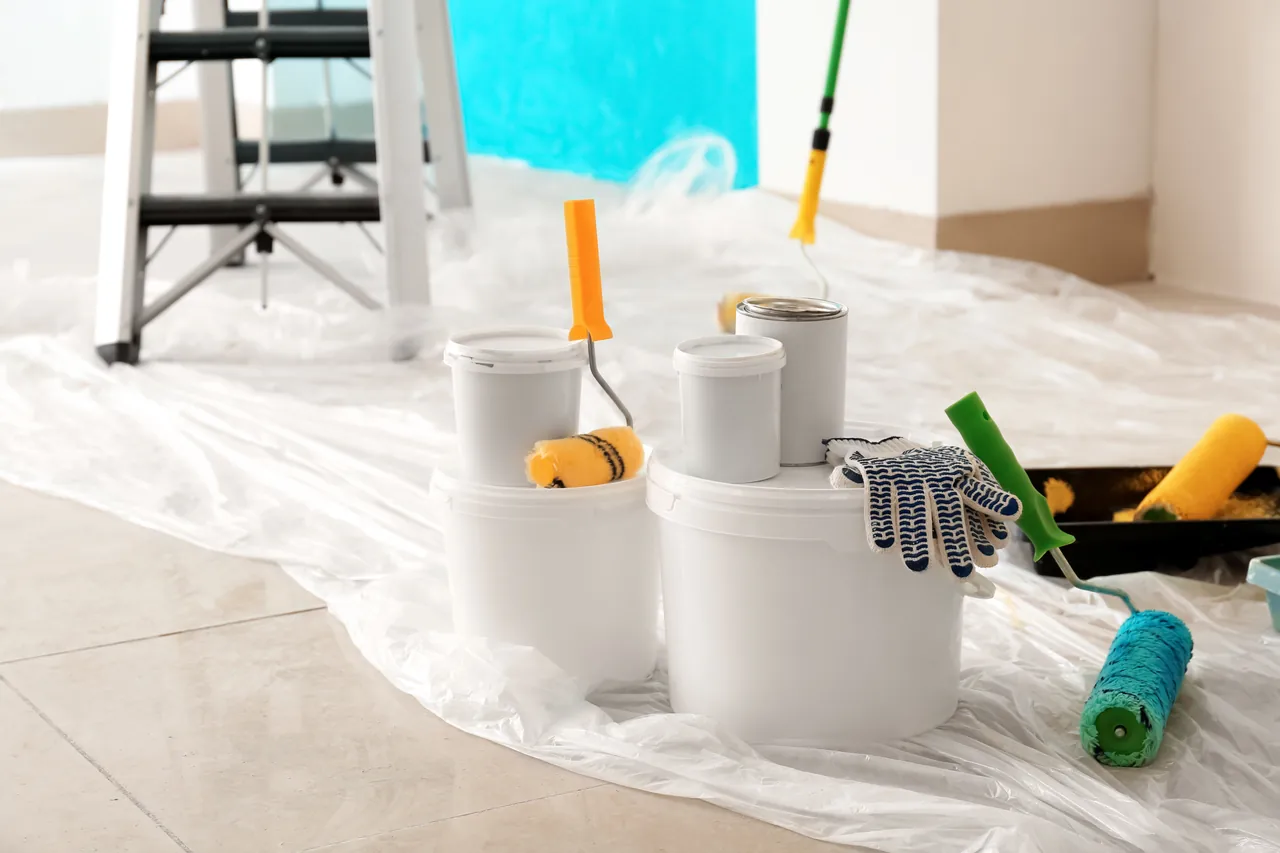 Paint supplies and drop cloth set up for an interior painting project