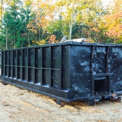 Large black dumpster placed on a construction site