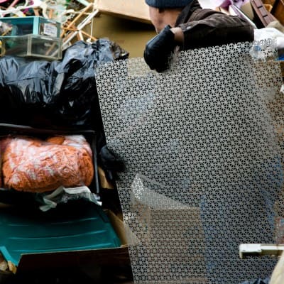 Contractor removing items from cluttered junk pile