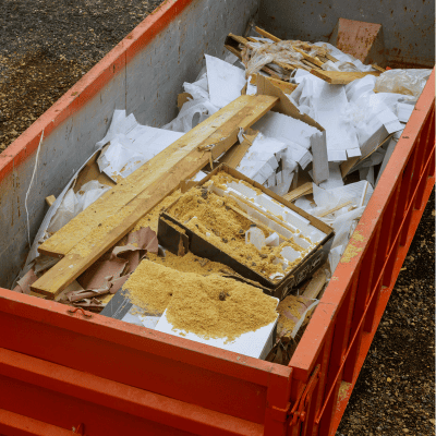 Large orange dumpster filled with debris and wood waste