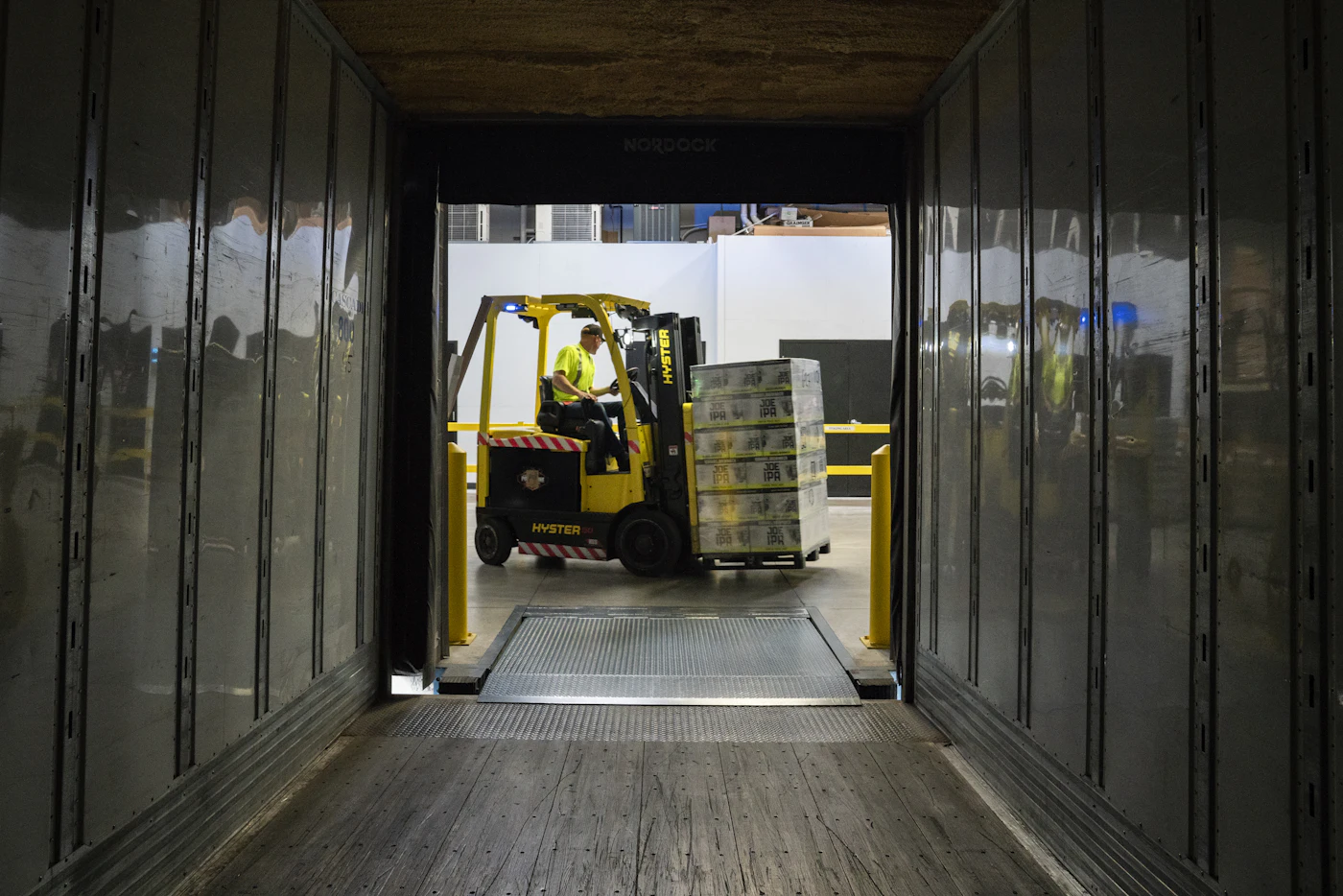 Forklift loading palletized goods from a loading dock