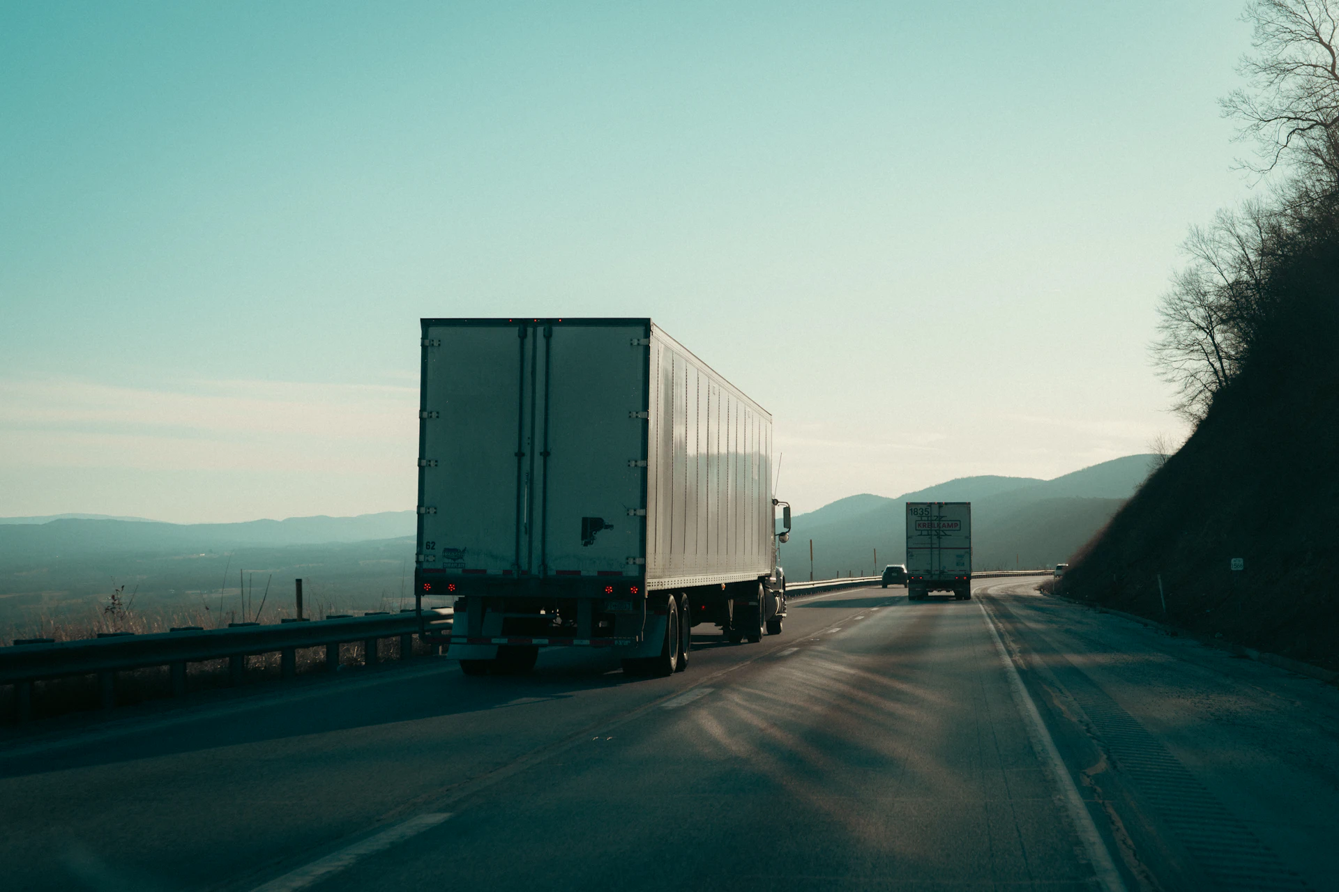Trucks on a highway at dusk