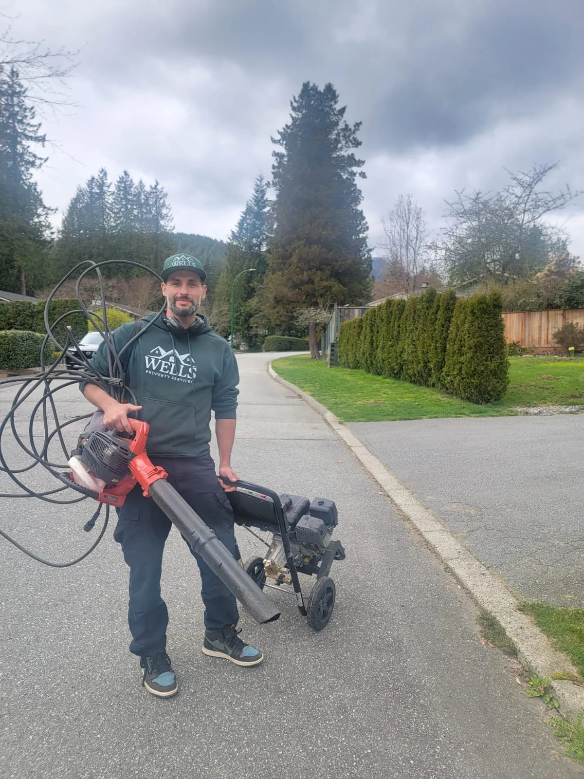 Devin Wells of Wells Property Services with pressure washing gear on a Metro Vancouver street