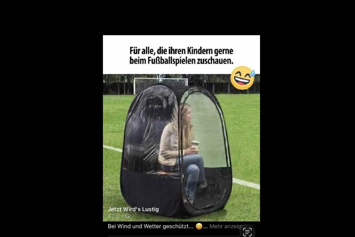 Frau Sitz in einem Zelt mit Sichtfenstern ringsrum auf dem Fußballplatz.