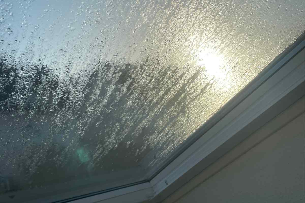 Sonnenstrahlen scheinen durch verregnetes Dachfenster.