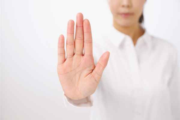 Frau macht eine Stopp-Handbewegung, um ihre Grenze zu setzen. Frau macht eine Stopp-Handbewegung, um ihre Grenze zu setzen.