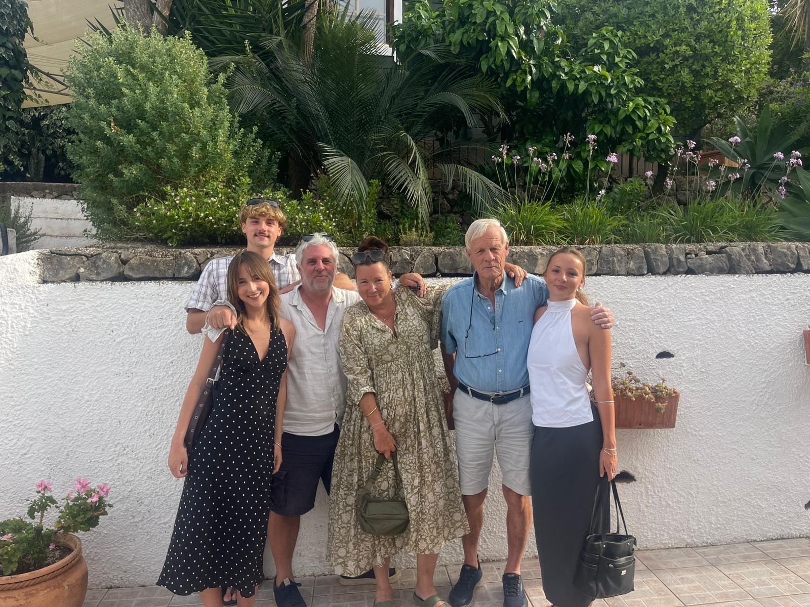 Matt&rsquo;s family, including his father-in-law, outside a white-walled house.