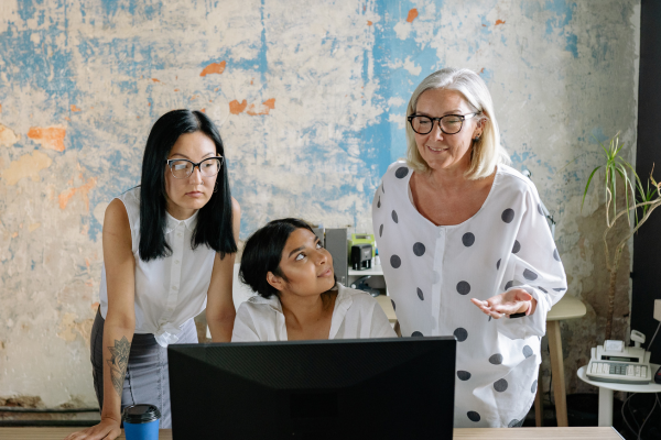 Owner showing team member how to complete a task on a computer